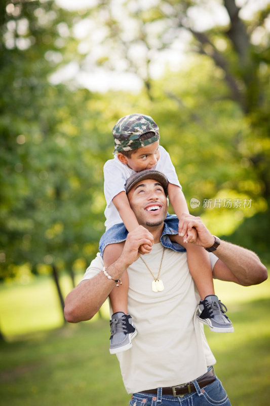 Happy Dad Carrying Son on His Shoulders Outside .快乐爸爸在外面扛儿子